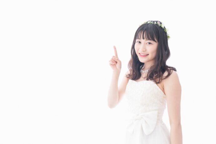 画像：人差し指を立てるウエディングドレスの女性
