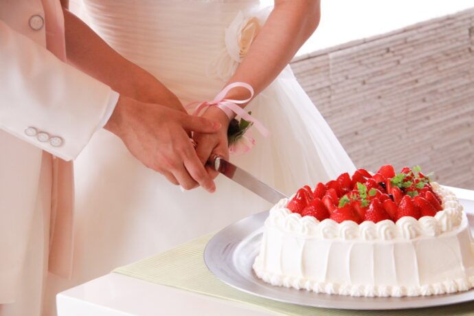 画像:ケーキ入刀を行う新郎新婦