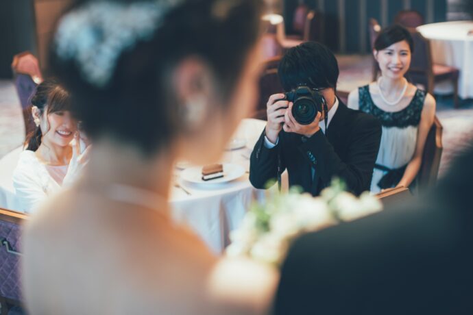画像:新婦にカメラを向ける男性ゲスト