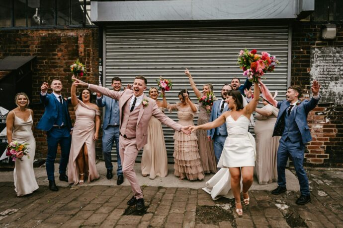 画像:はしゃいだポーズの新郎新婦とゲスト