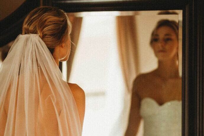 画像:鏡の前に立って姿をチェックする花嫁