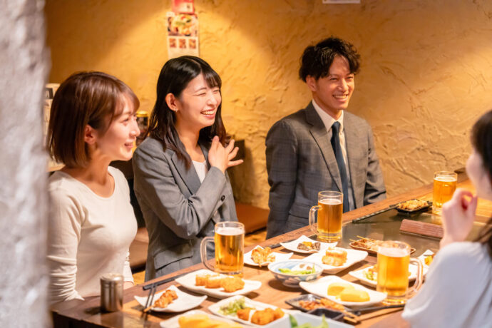 画像：同じテーブルを囲む男女