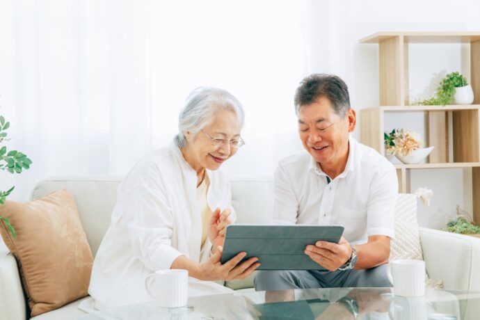 画像：タブレットを覗き込む高齢の男女