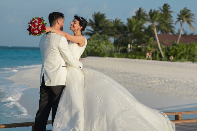 画像:波打ち際で肩に腕を回す新郎新婦