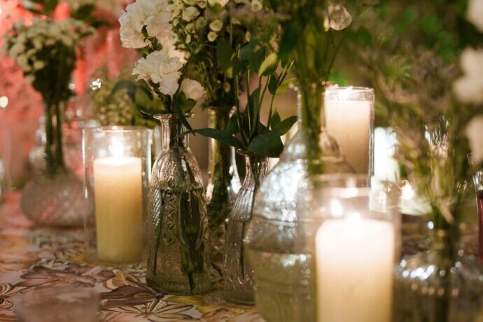 画像：卓上のキャンドルと花瓶に入った白い花