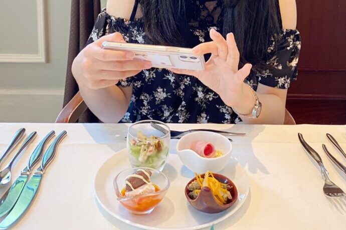 画像：前菜の写真を撮る女性