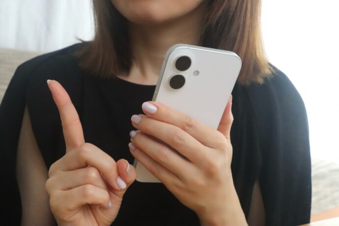 画像：スマホを片手に持った女性