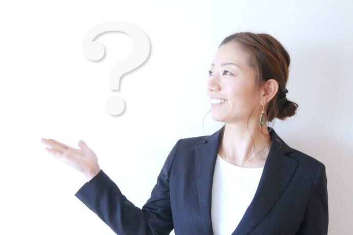 画像：はてなマークを浮かべたスーツの女性