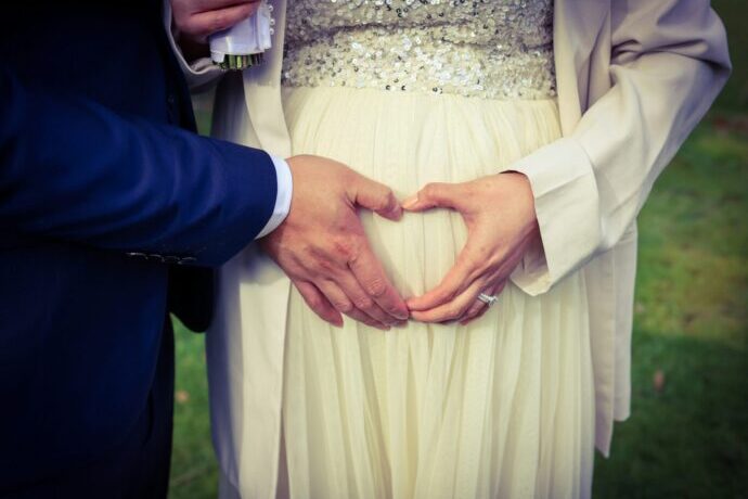 画像：お腹の前でハートを作る男女