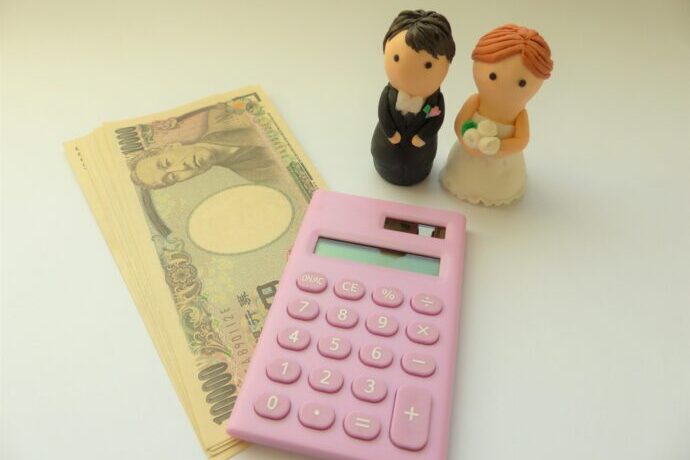 画像：電卓と新郎新婦のフィギュア