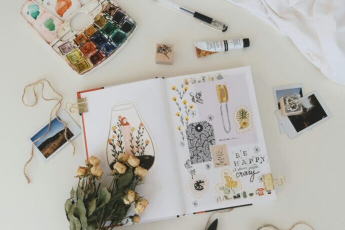 画像:切り抜きが貼られたスケッチブックと筆記用具