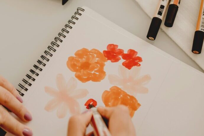 画像:スケッチブックに花を描いている