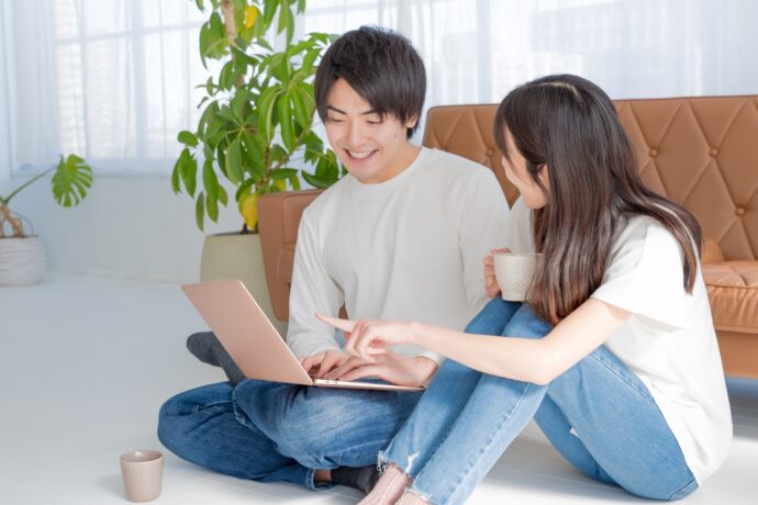 画像：パソコンを見ながら話し合う若い男女