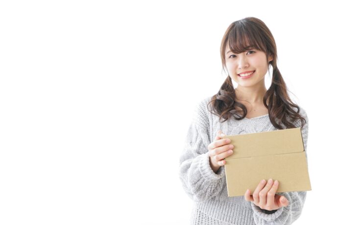 画像：茶封筒を手に持つ女性