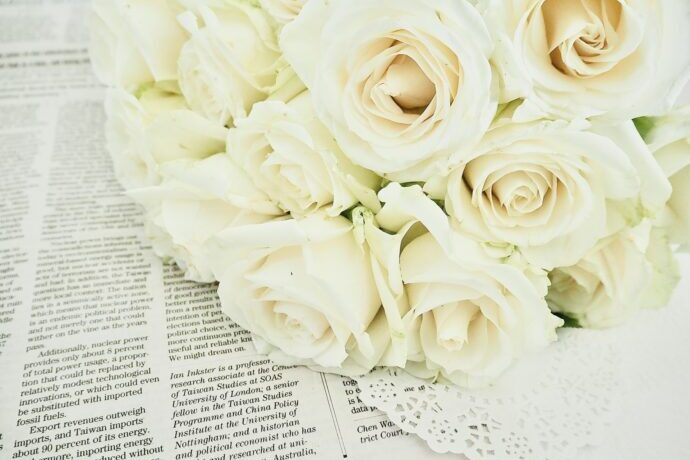 画像：英字新聞と白いバラのブーケ