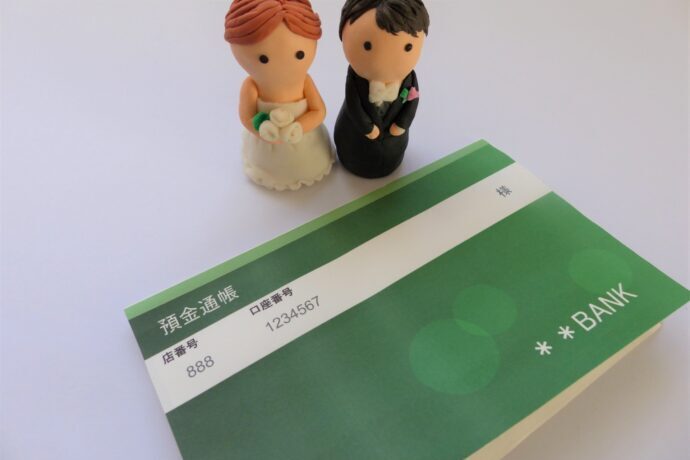 画像：通帳と新郎新婦のフィギュア