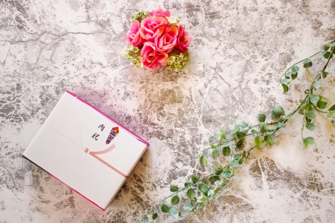 画像：のし紙のかかった内祝いの品とグリーン