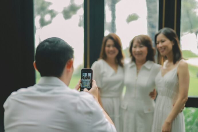 画像：女性三人組を撮影する男性