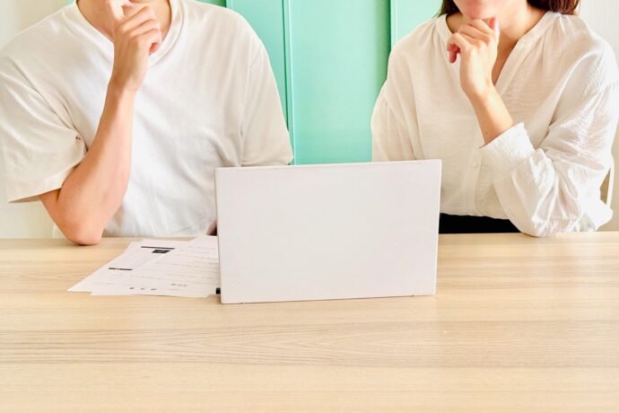 画像:パソコンの前で悩む男女