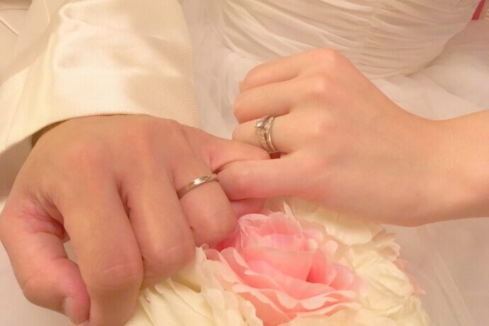 画像:小指を絡めた新郎新婦の左手