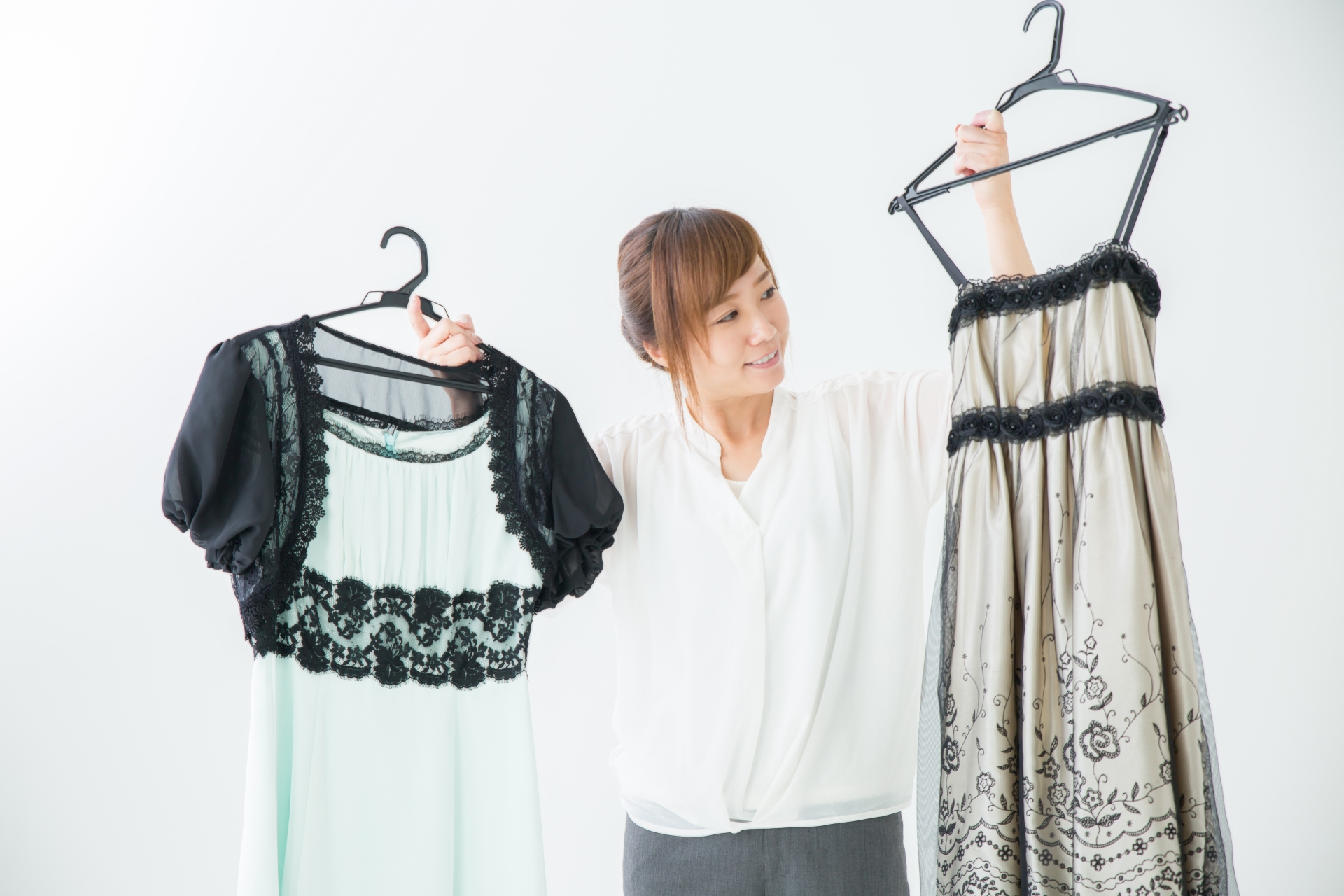 画像：ドレスを比べる女性