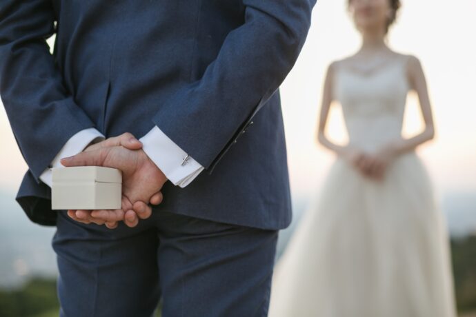 画像：指輪ケースを後ろ手に持つ男性